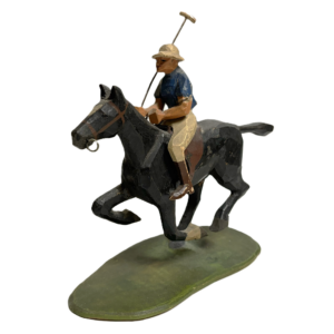 A hand carved wooden sculpture of a polo player who holds is mallet and is mounted on a black horse.