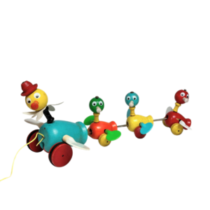 A classic toy, the Fisher Price wooden 'Ducks in a Row' pull toy, is a vibrant and playful piece. Crafted from wood, it features one large duck followed by three small ducks, all painted in multiple bright colors. The ducks are simple shapes with cute features, and as you pull the toy, the plastic wings spin.